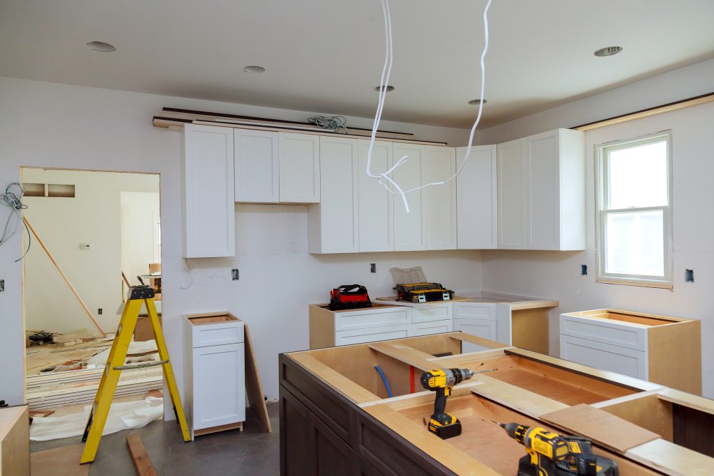 Modern kitchen renovation in Palm Desert with bright natural lighting, white cabinetry, and seasonal construction planning documents on the counter. Modern kitchen renovation in Palm Desert with bright natural lighting, white cabinetry, and seasonal construction planning documents on the counter.